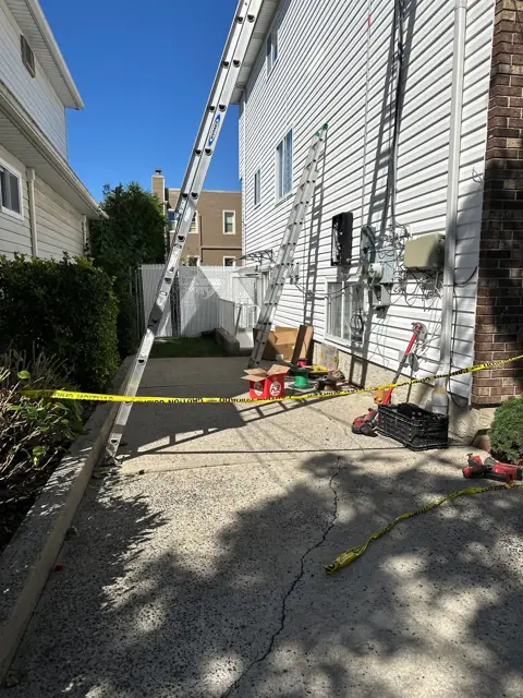 Ladder and materials staged in a side yard